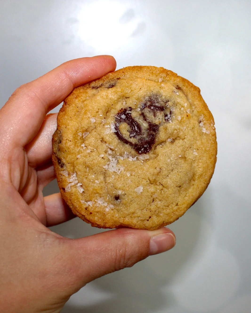 Caroline holding a chocolate chip cookie finished with flaky sea salt